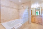 Gold remodeled master bath with large soaking tub, custom tile and glass work